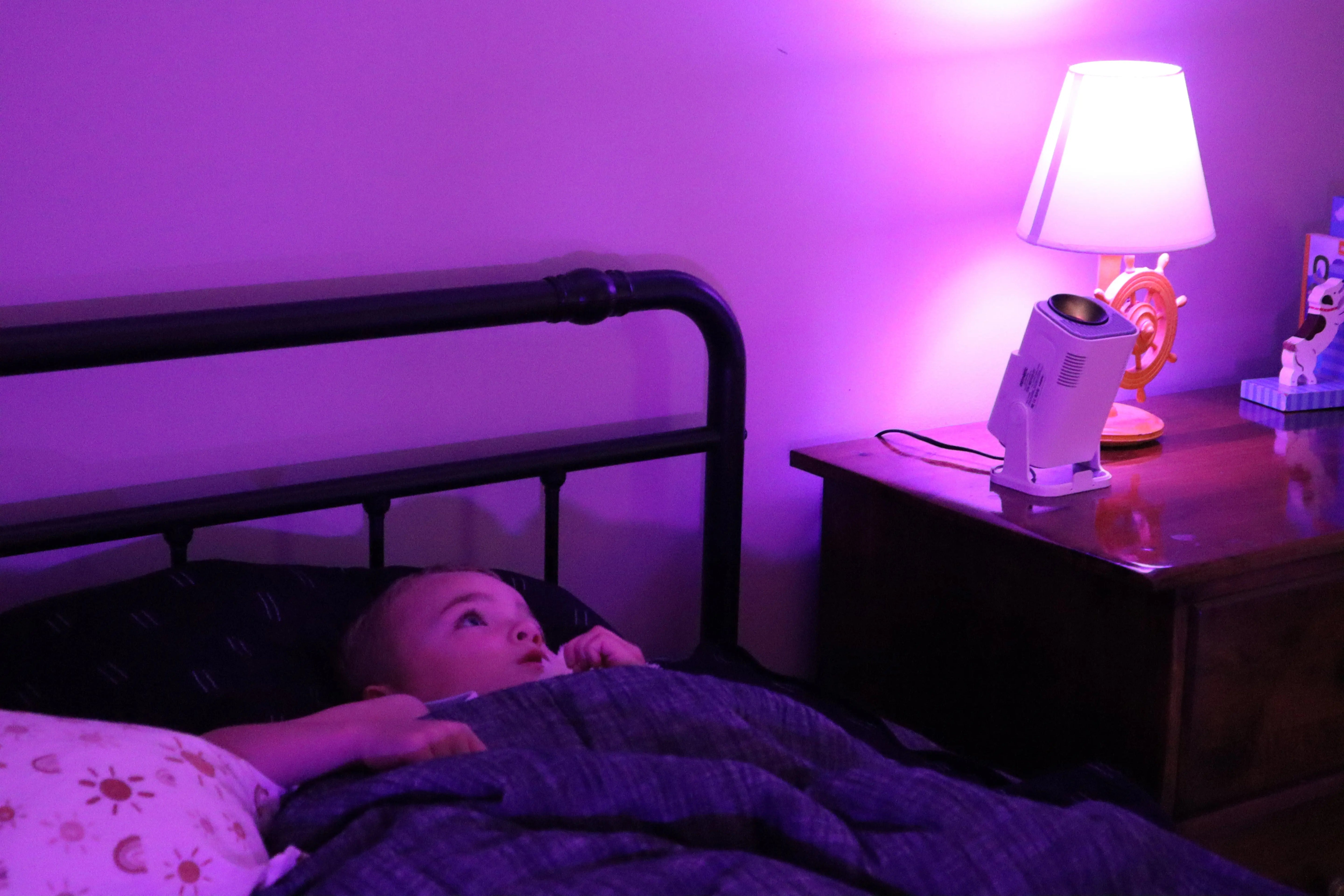 boy in bed learning with Ozmotic Learning Projector